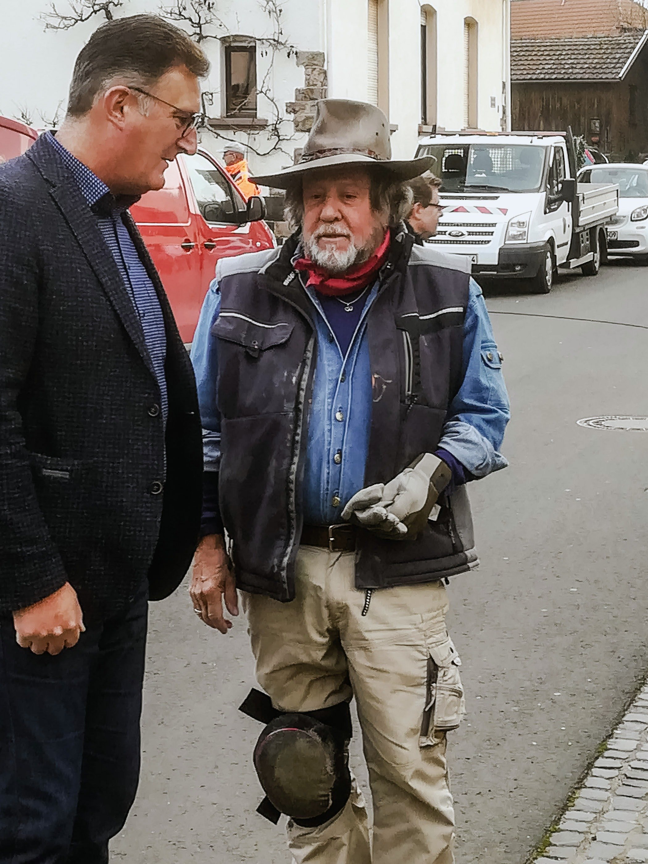 Gunter Demnig mit Hut im Gespräch mit einem Mann im Anzug