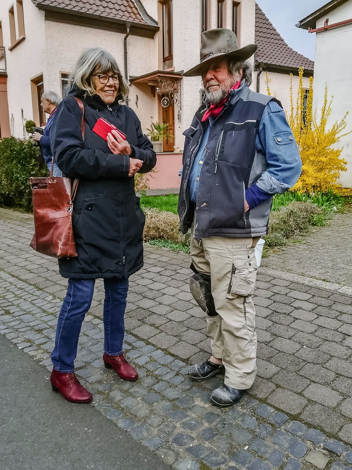 Gunter Demnig und eine Frau aus der Arbeitsgruppe stehen nebeneinander auf dem Gehweg
