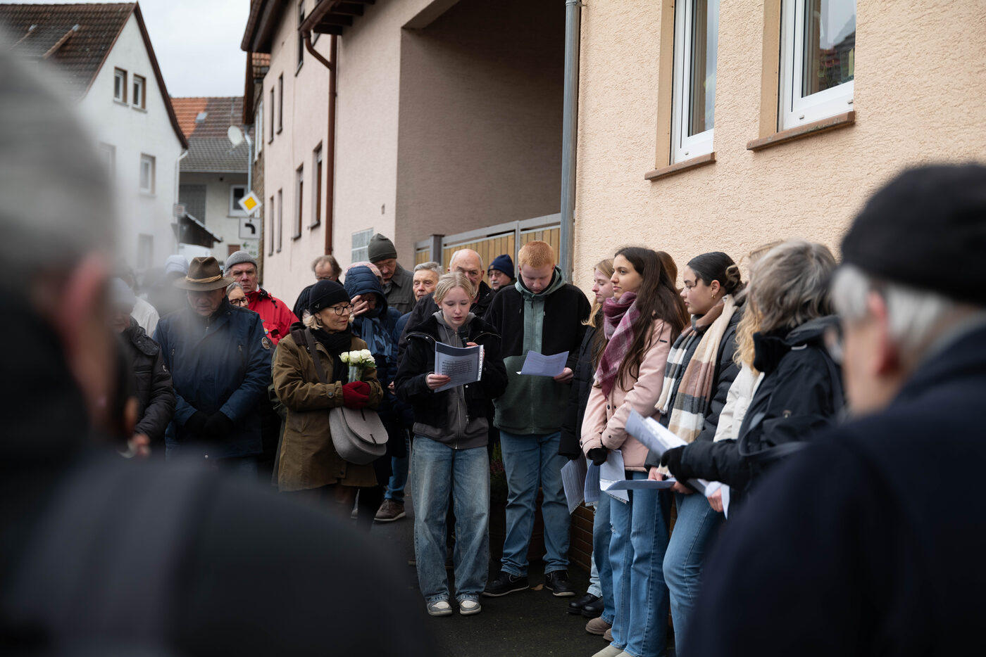 Junge Frauen mit Textblättern in der ersten Reihe der Zuhörenden.