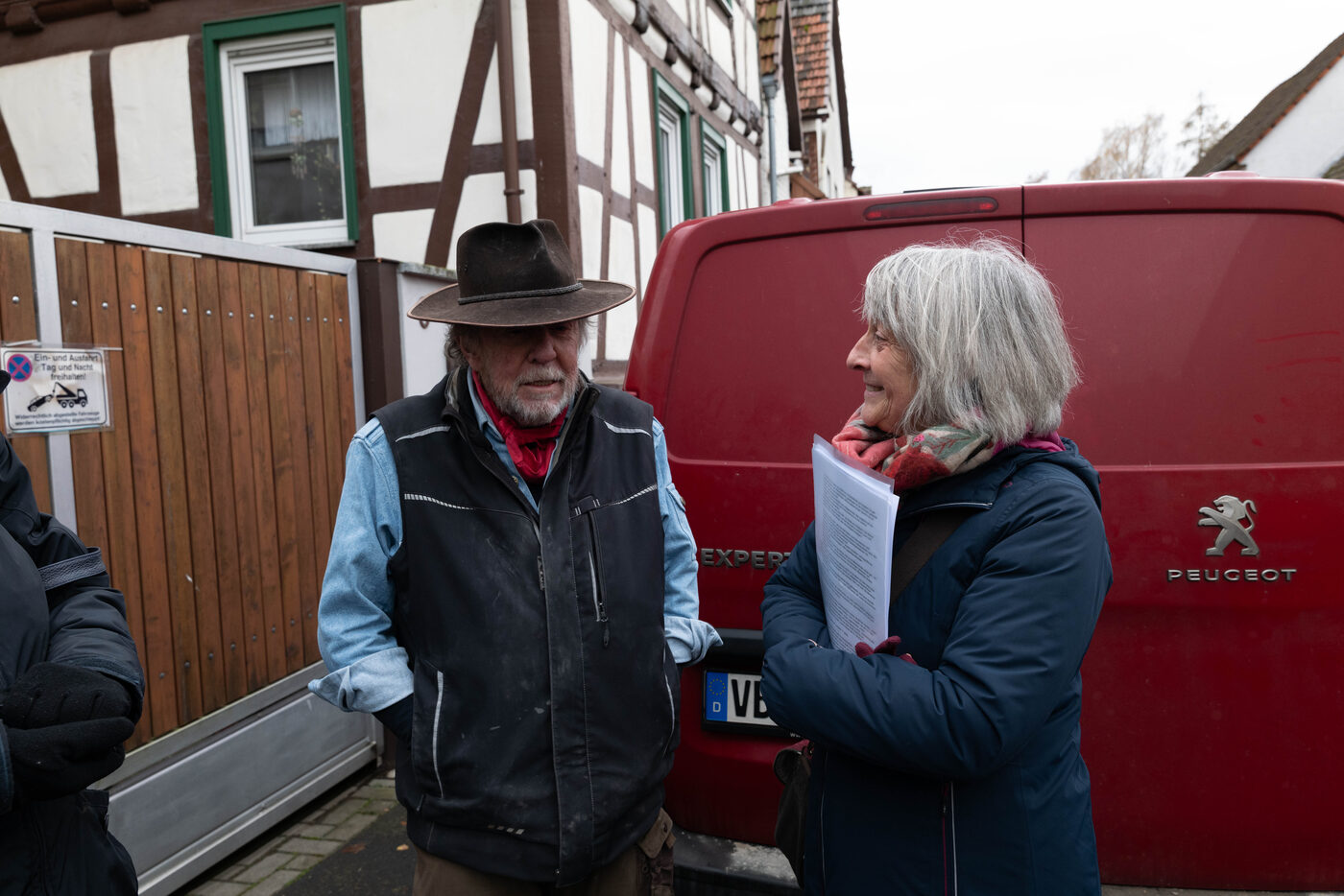 Gunter Demnig im Gespräch mit einer Frau, die Papiere hält.
